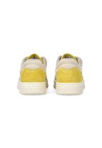 Beige suede sneakers with yellow suede accents at the heel. Features a textured rubber sole and cushioned tongue for comfort.