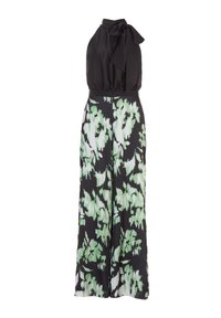 Combi-short noire à col halter avec un nœud papillon, ornée d'un imprimé floral vert et blanc sur des pantalons larges, fabriquée en tissu lisse.