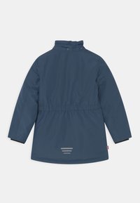 Zila, ūdensnecaurlaidīga jaka ar augstu apkakli, elastīgu jostasvietu un melnām aprocēm. Iekļautas atstarojošas svītras aizmugurē redzamībai.