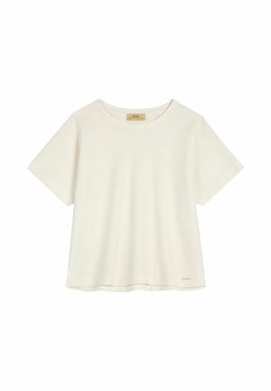 Biała koszulka z krótkim rękawem i okrągłym dekoltem, z małą beżową metką w dolnym lewym rogu, prezentowana na jednolitym białym tle.