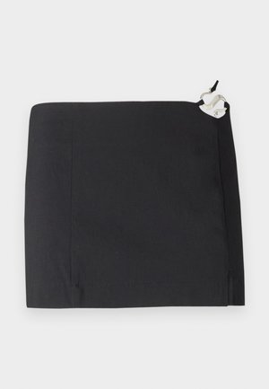 Čierna sukňa s elegantným dizajnom, rovnou siluetou a hladkou textúrou. Obsahuje biely akcentový detail z kovu na boku.