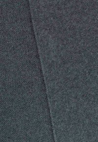 Grijze gebreide stof met een zachte textuur, met een subtiel gemêleerd patroon. Het materiaal lijkt rekbaar en heeft een dichtgeweven structuur.