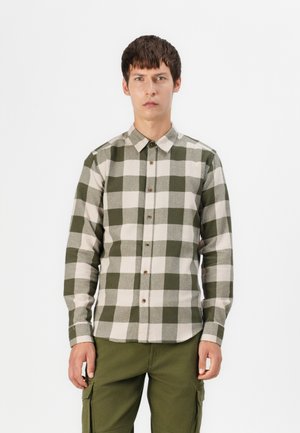 Heren overhemd met knopen in een groen en beige ruitpatroon. Gemaakt van zachte stof, met een gespreide kraag en bruine knopen. Gestyled met groene cargobroeken.