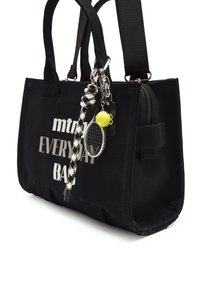 Zwarte canvas schoudertas met de tekst "mtrm" en "EVERYDAY BAG" in het wit. Beschikt over een ritsvak en sleutelhangeraccenten, waaronder een tennisbal.