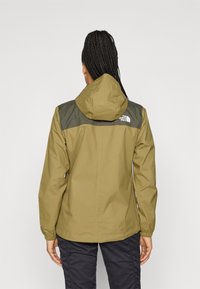 Αδιάβροχο μπουφάν σε ελαιί πράσινο χρώμα με γκρι επάνω τμήμα, ρυθμιζόμενο κουκούλι, ελαστικά μανίκια και το λογότυπο The North Face στην πλάτη.