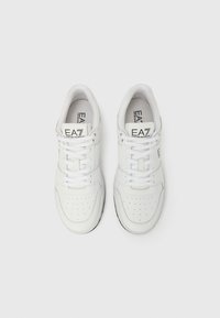 Pantofi sport albi din piele, cu vârf rotund, detalii perforate și guler căptușit. Au șireturi albe și o etichetă cu logo pe limbă.