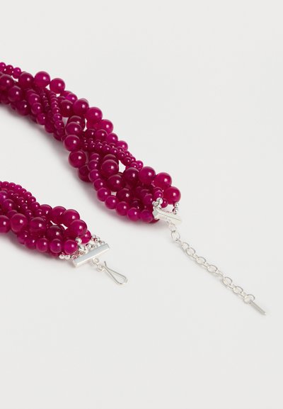 Πολύσειρο κολιέ με γυαλιστερές στρογγυλές σκούρο-ροζ χάντρες και ασημένιο κούμπωμα με ρυθμιζόμενη αλυσίδα σε λευκό φόντο.