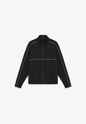 Svart glidelåsjakke med hvite pipinger langs ermene og brystet, to glidelåslommer foran og en stående krage.