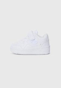 Baskets blanches avec une sangle Velcro, en matériau synthétique, zone des orteils perforée et semelle en caoutchouc texturé. Présente un logo bien en évidence sur le côté.