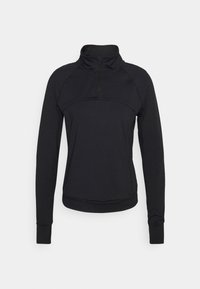 Camiseta deportiva negra de manga larga con cuello de media cremallera, textura suave, diseño ajustado y costuras planas, que presenta un detalle de panel en el pecho.