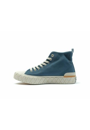 Basket montante avec une tige en toile bleue, capuchon de orteil en caoutchouc blanc, semelle texturée et accents beiges sur le talon et le côté.