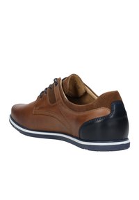 Scarpa di pelle marrone con un tacco accentato in navy texture, suola bianca e lacci scuri. Presenta finiture lisce e scamosciate sulla parte superiore.