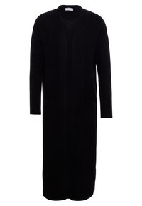 Lång svart cardigan gjord av ett mjukt stickat material. Har en öppen front, två framfickor och ribbade ärmslut. Ingen knäppning.