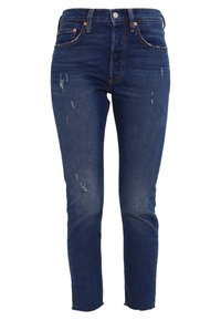 Getailleerde donkerblauwe spijkerbroek met distressed details, ontwerp met vijf zakken en een cropped zoom. Voorzien van metalen beslag en een ritssluiting.