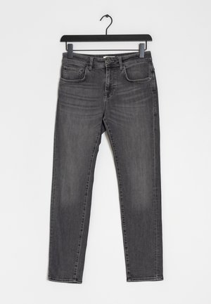 Jeans de mezclilla gris con corte ajustado, diseño de cinco bolsillos y cierre de botón. Presentan un desvanecido sutil y una textura suave.