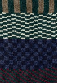 Tejido de punto con franjas verticales en verde y marrón, patrones de cuadros horizontales en azul marino y crema, y una sección inferior de cuadros en rojo y verde.