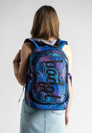 Mehrfarbiger Rucksack mit einem blauen und lila Palmenblattmuster, schwarzer Schrift, gepolsterten Schulterriemen und mehreren Reißverschlussfächern.