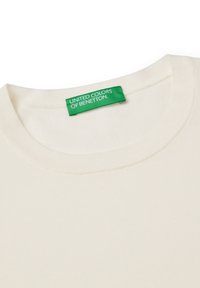 Cremfarbener T-Shirt mit rundem Halsausschnitt. Verfügt über ein grünes Etikett mit dem Text "UNITED COLORS OF BENETTON". Weiche Textur, lässiges Design.