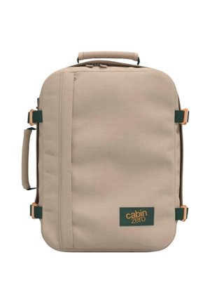 Beigen värinen suorakulmainen pehme matkalaukku, jossa ylä- ja sivukahvat, vihreät solkihihnat ja "cabin zero"-logo etutaskussa.
