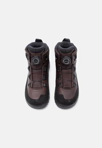 Prill pruunidest ja mustadest matkajalatsitest, millel on must Boa-kett, kõrge pahkluutoe ja pehmendatud sisemine vooder, vaadatuna ülalt.