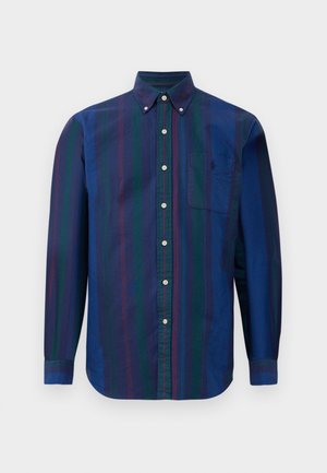 Chemise à boutons avec des rayures verticales en bleu foncé, vert et bordeaux. Fabriquée dans un tissu à texture lisse et dotée d'une poche poitrine.