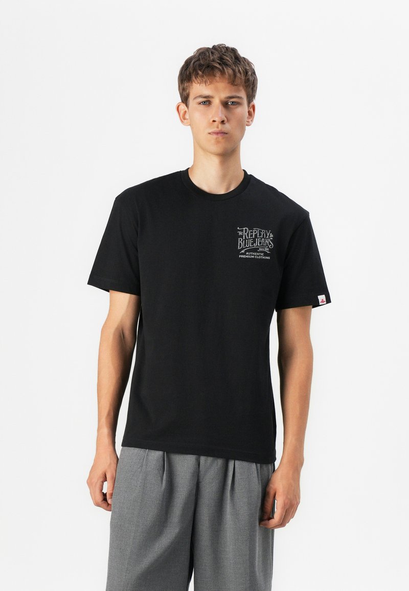 Black cotton t-shirt with short sleeves and round neckline, featuring a graphic print on the left chest and a small label on the right sleeve.