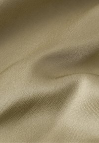 Glatte, lichtgoldene Stoff mit einem subtilen Glanz, der eine weiche Textur und sanfte Falten aufweist und eine gleichmäßige Oberfläche ohne Muster zeigt.