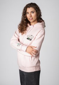 Lichtroze hoodie met kangoeroezak, trekkoord kap en geborduurde graphic details op de borst en mouw. Zachte katoenen mix materiaal.