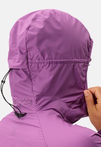 Paarse lichtgewicht jas met capuchon, voorzien van een elastische trekkoord, een gladde textuur en bedrukte tekst langs de naad. Achteraanzicht, hand die de capuchon aanpast.