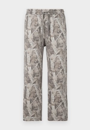 Lockere Jogginghose mit einem grau-beigen Camouflage-Muster aus Herbstblättern und Zweigen.