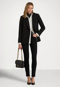 Fekete kétsoros blézer fehér inggel, fekete testhezálló nadrággal, fekete magassarkúval és egy kis fekete táskával arany lánccal.