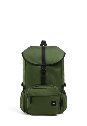 Groene rugzak met bovenklep en zwarte gesp, voorvak met rits, zijvakjes en Vans-logo patch op het voorvak.