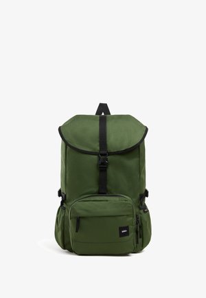 Groene rugzak met bovenklep en zwarte gesp, voorvak met rits, zijvakjes en Vans-logo patch op het voorvak.