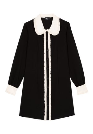 Sort kjole med hvid flæsekrave og knapstolpe, lange ærmer med hvide manchetter og en afslappet pasform.