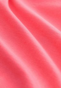 Tela coralina con una textura suave, que muestra un brillo sutil y una caída suave. El material presenta patrones de tejido finos en toda su superficie.