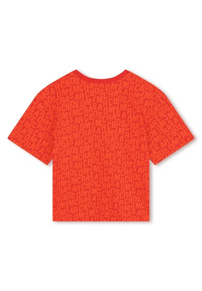 T-shirt rouge à manches courtes présentant un motif texturé de texte répété dans des nuances de rouge variées. Col rond, coupe décontractée.