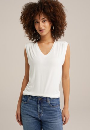 Top bianco senza maniche e con scollo a V realizzato in tessuto morbido, caratterizzato da una vestibilità comoda. Abbinato a jeans blu a vita media. Design semplice senza motivi.