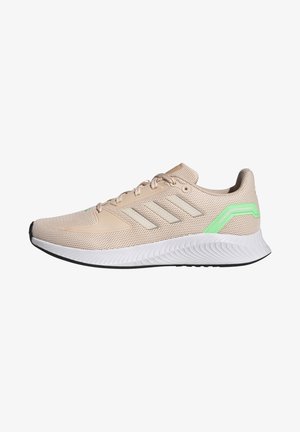 Beige sportieve schoen van gaas met drie reflecterende strepen, groene accent op de hiel, gewatteerde witte tussenzool en gestructureerde zwarte buitenzool.