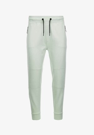 Lys grønne joggers i blødt materiale med elastisk talje og snøre, tapered ben og lynlåslommer på siderne. Glat tekstur med paneldetaljer.
