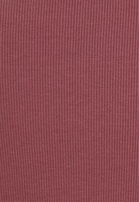 Ribbad tyg i djup bordeaux, med vertikala linjer och en mjuk textur. Materialet verkar sträckt och lättviktigt.