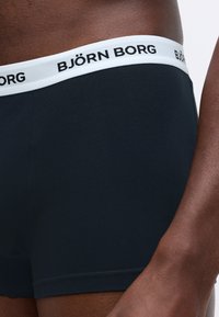 Ανδρικά σκούρα ναυτικά μποξεράκια με λευκή ζώνη που φέρει μαύρ�ο κείμενο "BJÖRN BORG". Το ύφασμα φαίνεται μαλακό και λείο, εφαρμόζοντας σφιχτά.