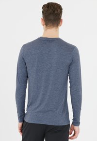 Långärmad skjorta i melerad marinblått tyg, rundad hals, slim fit, slät textur, med en enkel design utan synliga logotyper eller mönster.