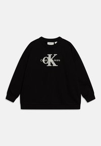 Sudadera negra hecha de tela suave, con cuello redondo, mangas largas y un prominente logo plateado "Calvin Klein Jeans" en la parte delantera.