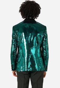 Błyszcząca, turkusowa marynarka z cekinami, o strukturalnym kroju, z czarnym aksamitnym kołnierzem i dopasowanym fasonie, odbijająca światło dzięki lśniącej, teksturowanej powierzchni.