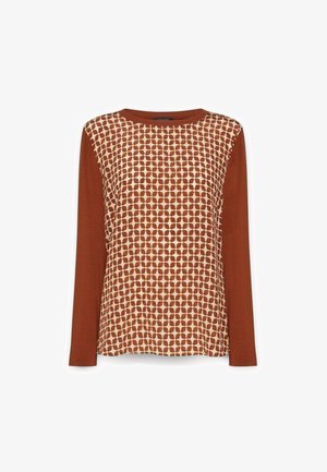 Pitkähihoinen toppi, jossa on ruosteen värinen ja kerma värinen pistekuvio, sekä yksivärinen ruosteen värinen kangas hihoissa. Pyöreä pääntie, rento malli.