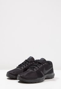 Scarpe sportive nere con tomaia in rete testurizzata, chiusura con lacci e suola in gomma liscia. Presentano un marchio discreto sul lato.