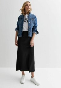 Veste en denim, t-shirt graphique blanc, jupe maxi noire, baskets blanches. Caractéristiques : design en denim classique et texture de tissu lisse.