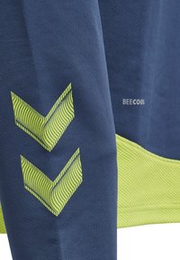 Navy träningsskjorta med texturerad tyg, med neongröna chevronmönster och en "BEECOOL"-logotyp på sidan.