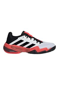 Herrentennisschuh mit einem weißen Obermaterial, schwarzen Akzenten und roten Details. Verfügt über ein texturiertes Mesh-Design, eine Gummisohle und eine markante Schnürung.