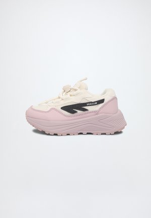 Kraftig sneaker med lyserød sål og tå, cremefarvet overdel, sort zigzag-design og "SHADOW" tekst på siden mod en ensfarvet lys baggrund.